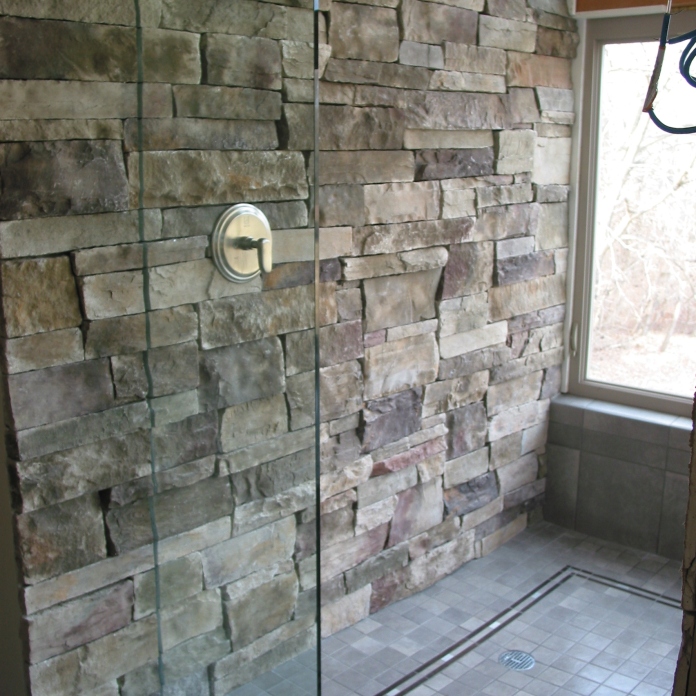 - Curbless shower design with stone accent wall in master-bath shower.